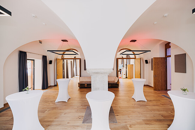 Cocktailtische, moderne Einrichtung und Beleuchtung des Gebäudes "Brennerei" der Würzburger Eventlocation Gut Wöllried
