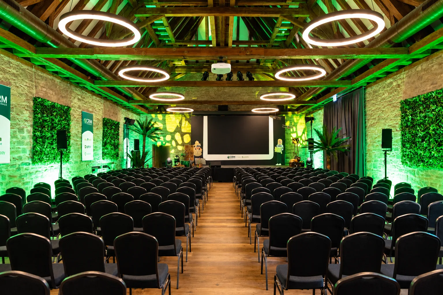 Konferenz in der Festscheune auf Gut Wöllried mit Reihenbestuhlung, Bühne und grüner Lichtinszenierung